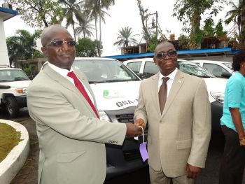 DMA Varney Sirleef receives Keys from UNDP's Ceophas Torori at the hand over of vehicles